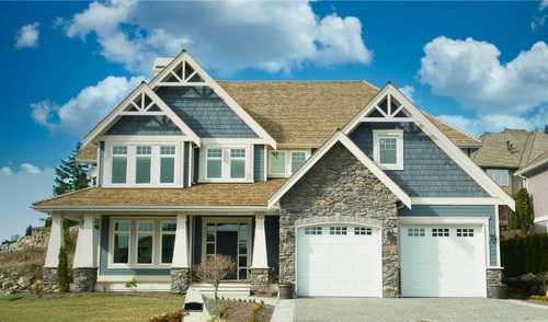 front photo of a 2 story house with blue siding and brick